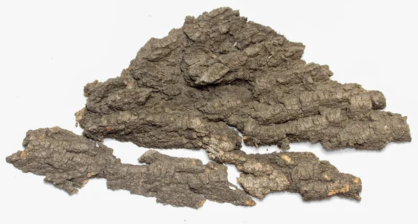 Üstünde birkaç parça ağaç kabuğu olan bir yığın odun. Kabuk kahverengi ve pürüzlü bir dokusu var. Ağaç kabuklarının etrafına saçılmış odun parçaları doğal ve kırsal bir görünüm yaratıyor.