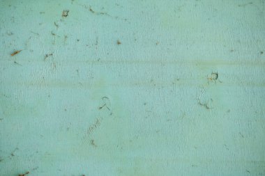 Tahta desenli yeşil bir duvar. Duvar küçük deliklerle kaplı ve pürüzlü, pürüzlü bir yüzeyi var. Sahne biraz kaotik ve düzensiz.