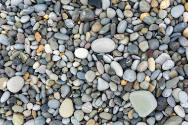 Ortasında tek bir taş olan bir taş yığını. Kayaların boyutları ve renkleri farklıdır ve görüntünün genel havası sakin ve sakindir.