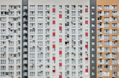 Kırmızı ve beyaz süslemeli bir sıra apartman. Binalar yüksek ve birçok pencereleri var.