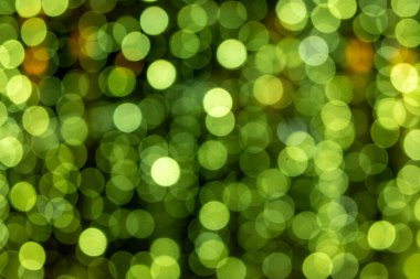 Bir sürü küçük yeşil daireli yeşil bir arka plan. Daireler bulanık ve örtüşüyor, hareket ve enerji hissi yaratıyor. Manzara canlı ve dinamiktir.