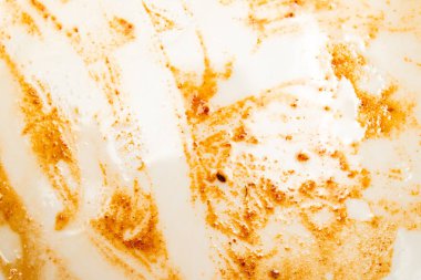 Kahverengimsi kıvrımlı beyaz bir arka plan. Girdap dağınık ve bir sürü kahverengi lekesi var.