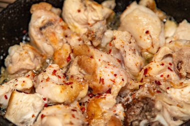 Bir tavuğun üstü kırmızı biber taneleriyle kaplıdır. Tavuk pişti ve servis için hazır.