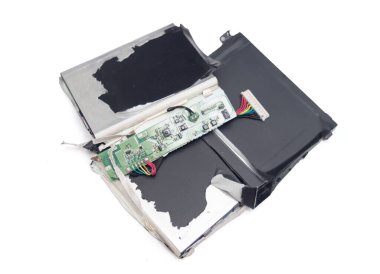 Yeşil pilli kırık bir cep telefonu. Akü kayıp ve telefon parçalanmış.