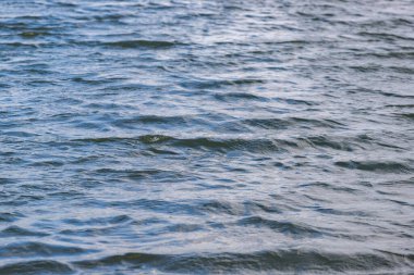 Su sakin ve hareketsiz. Gökyüzü açık ve mavi. Su koyu ve koyu mavi.