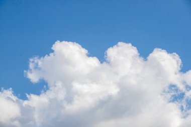 Gökyüzü mavi ve bulutlu. Bulutlar beyaz ve kabarık. Gökyüzü açık ve parlak