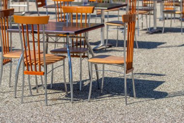 Etrafında sandalyeler olan bir masa toplantı için hazırlanıyor. Sandalyeler masanın etrafında yarı daire şeklinde dizilmiş, bazı sandalyeler masaya bakıyor ve diğerleri uzağa bakıyor.