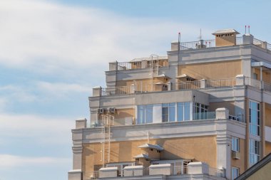 Bir sürü penceresi ve çatısı olan yüksek bir bina. Bina kahverengi ve bir sürü penceresi var.