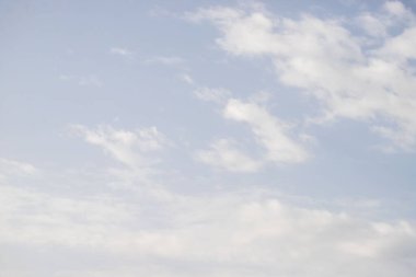 Gökyüzü açık ve mavidir. Birkaç bulut etrafa saçılmıştır. Bulutlar küçük ve beyazdır ve gökyüzüne yayılmışlardır. Manzara sakin ve huzurlu, mavi gökyüzü