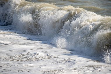 Okyanus dalgalı ve dalgalar yüksek. Su beyaz ve gökyüzü mavi.