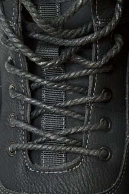 Siyah dantelli siyah bir ayakkabının yakın çekimi. Dantel düğümlenmiş ve siyah beyaz deseni var.