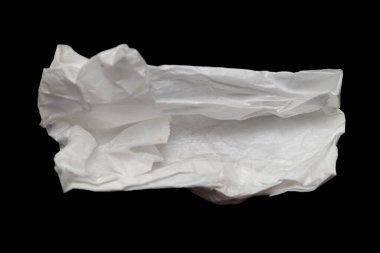 Bir kağıt parçası yırtılmış ve siyah bir arka planda duruyor. Boşluk ve savunmasızlık kavramı, kağıt mendiller artık açıkta ve elementlere karşı savunmasız.