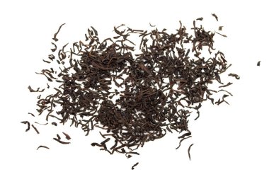 A pile of black tea leaves on a white background. The leaves are scattered and appear to be from a tea bag