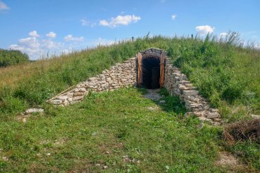 Üzerinde taş bir yapı olan küçük, çimenli bir tepe. Yapı kapısı olan küçük bir mağara. Mağara çimlerle çevrili ve o huzurlu, tenha bir yer.