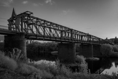Köprü, sudaki köprünün bir yansımasıyla bir nehri gerer. Köprü eski ve yıldızımsı bir tasarımı var.
