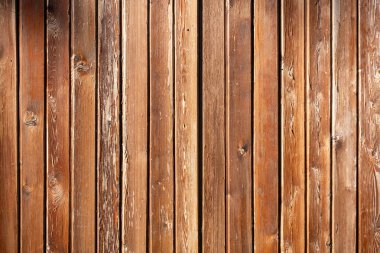 Tahta bir duvar ve kumlu bir dokusu var. Tahta kahverengidir ve doğal bir görünüşü vardır. Duvar boş ve ne mobilyası ne de dekorasyonu var.