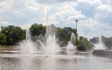 İçinden bir sürü küçük su fışkıran büyük bir çeşme. Su havaya fışkırıyor ve sisli bir atmosfer yaratıyor. Sahne huzurlu ve rahatlatıcı, suyun sesiyle.