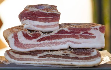 Üç dilim pastırma üst üste istiflenmiş. Pastırma biber ve tuzla tatlandırılmış.