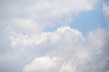 Gökyüzü bulutlarla dolu ve güneş onların arasından parlıyor. Bulutlar beyaz ve yumuşaktır. Huzurlu ve huzurlu bir atmosfer yaratırlar.