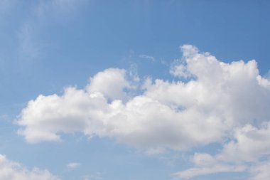 Birkaç bulutlu mavi bir gökyüzü. Gökyüzü berrak ve parlak ve bulutlar gökyüzüne dağılmış durumda. Bulutların derinlik hissi arttıkça manzara huzurlu ve huzurlu.