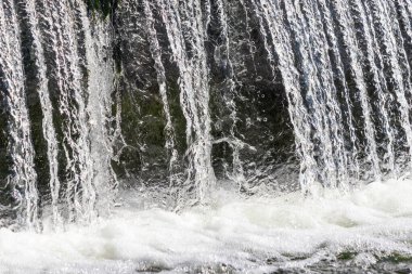 A waterfall with a lot of water coming out of it. The water is clear and looks very refreshing