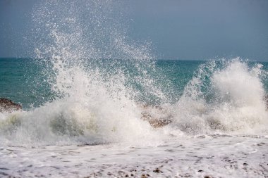 Okyanus dalgalı ve dalgalar yüksek. Su beyaz ve gökyüzü mavi.
