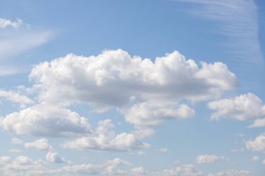 Gökyüzü mavi ve bulutlu. Bulutlar beyaz ve kabarık. Gökyüzü açık ve parlak