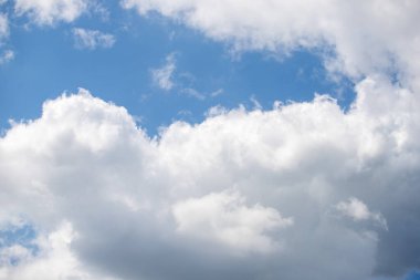 Gökyüzü mavi ve bulutlu. Bulutlar beyaz ve kabarık. Gökyüzü açık ve parlak