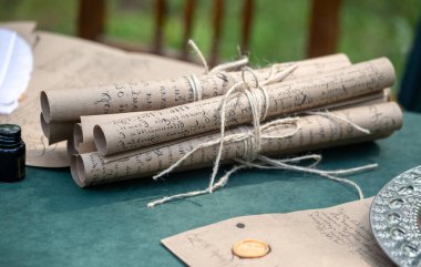 Bir sürü eski kağıt iple birbirine bağlanmış. Kağıtlar üzerine yazılmış ve geçmiş bir döneme ait gibi görünüyor. Nostalji anlayışı ve gazetelerin içeriğiyle ilgili merak.