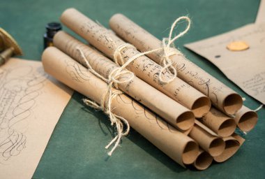 A stack of old parchment scrolls tied together with string. The scrolls are tied in a way that they are not touching each other