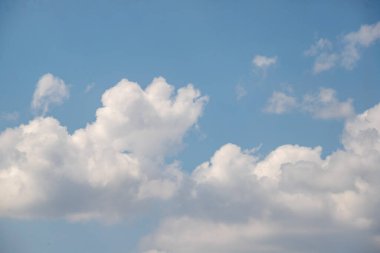 Gökyüzü mavi ve bulutlu. Bulutlar beyaz ve kabarık. Gökyüzü açık ve parlak