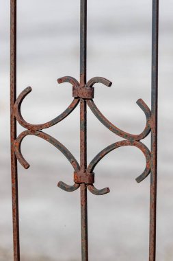 Haç ve elmas tasarımlı paslı demir bir kapı. Kapı eski ve yıpranmış, ama hala biraz cazibesi var.