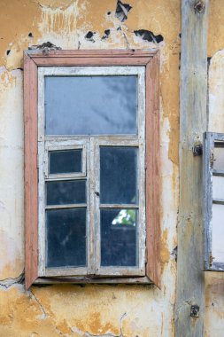 Üzerinde ayna olan bir pencere çok hasarlı bir binadadır. Pencere eski ve bir sürü çatlak var.