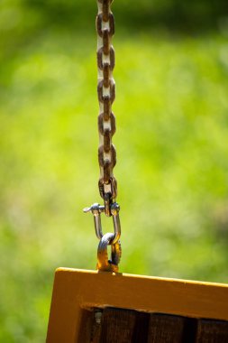 Zincir salıncakta sallanıyor ve zincir metal bir çubuğa bağlı.