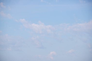 The sky is blue with a few clouds scattered throughout. The clouds are white and fluffy, giving the sky a peaceful and serene appearance