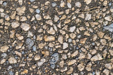 Etrafa dağılmış birkaç küçük kayanın olduğu kayalık bir yüzeye yakın çekim. Görüntü sert ve dayanıklı, dayanıklılık ve dayanıklılık hissi veriyor.