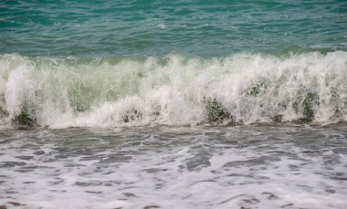 Okyanus sakin ve dalgalar küçük. Su mavinin güzel bir tonu. Huzurlu ve huzurlu bir sahne.