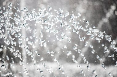 Havada bir sürü küçük damlacık olan bir su spreyi. Su damlacıkları beyaz ve görüntüye dağılmış.