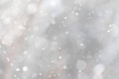 Gökyüzünden düşen kar tanelerinin bulanık bir görüntüsü. Kar taneleri görüntünün her tarafına dağılmış, hareket ve kaos hissi yaratıyor. Sahne sükunet ve huzurdan ibarettir.