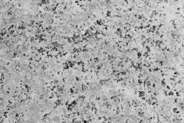 Pek çok küçük deliği olan gri bir taşın yakın çekimi. Taş çok pürüzlü ve bir sürü dokusu var.