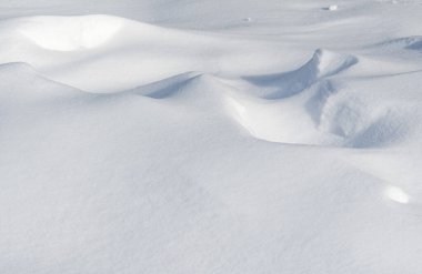 Birkaç küçük kar yığınıyla kaplı bir kar tarlası. Kar beyaz ve tarla boş.