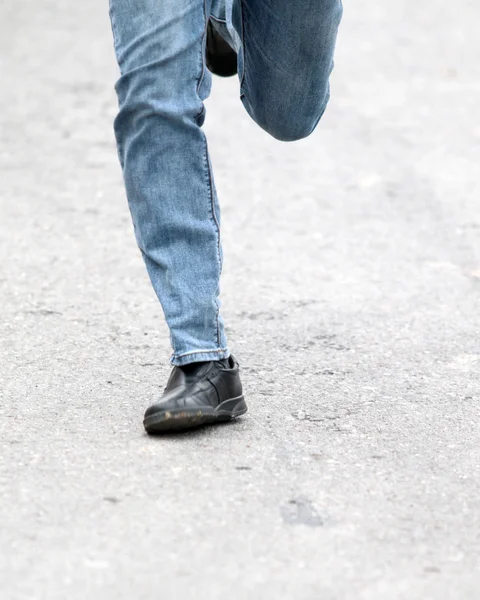 Pés de homem em jeans azul em sapatos de perto, em movimento — Fotografia de Stock