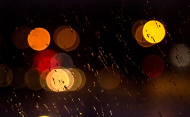 Yağmurda soyut gece şehir ışık ve bokeh araba ön cam ile kaplı