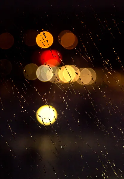 Abstract night city light and bokeh through car windscreen covered in rain — Stock Photo, Image