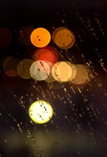 Abstract night city light and bokeh through car windscreen covered in rain — Stock Photo, Image