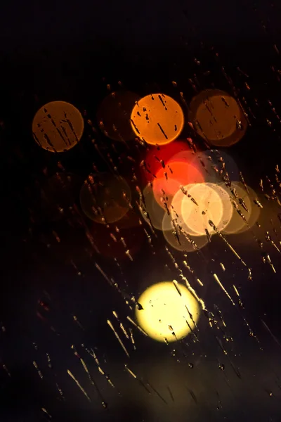 Lumière abstraite de la ville de nuit et bokeh à travers le pare-brise de voiture couvert de pluie — Photo