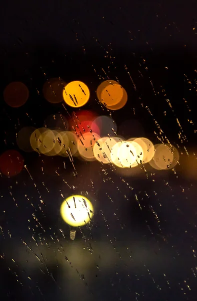 Abstract night city light and bokeh through car windscreen covered in rain — Stock Photo, Image