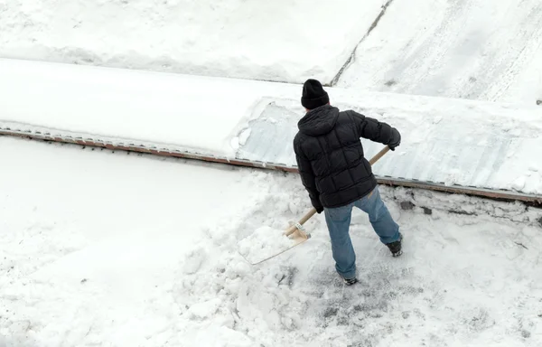 Člověk čistí sníh, pohled shora — Stock fotografie