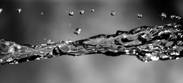 Water spuiten op een donkere achtergrond — Stockfoto