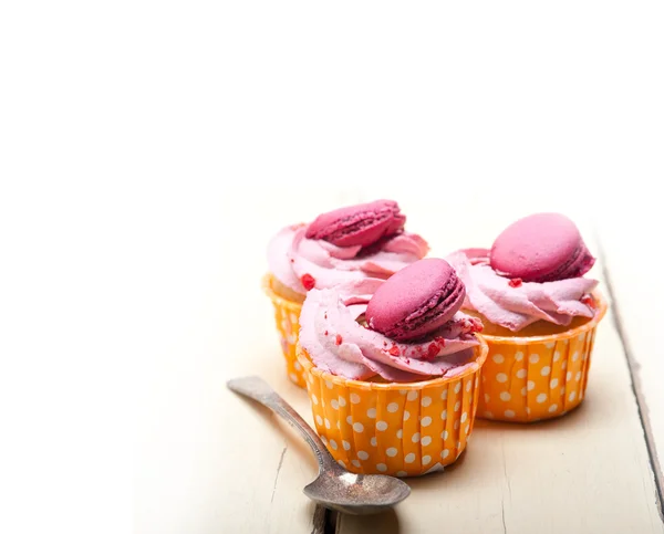 Pink berry cream cupcake with macaroon on top — Stock Photo, Image